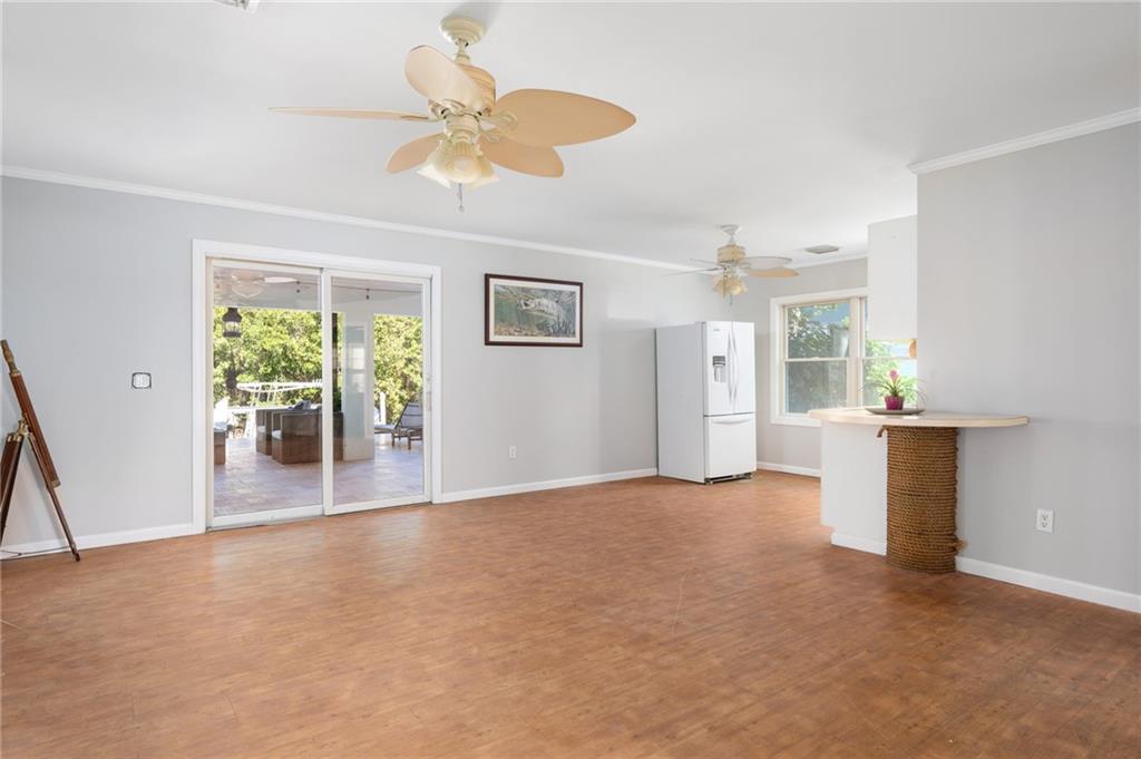 5440 95th Street Sebastian, FL 32958 - Photo 23 of 36 a view of a livingroom with wooden floor and a ceiling fan