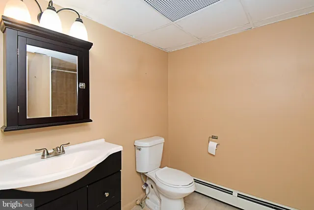 a bathroom with a toilet a sink a mirror and vanity