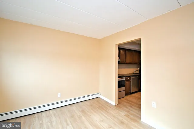 a view of empty room with kitchen