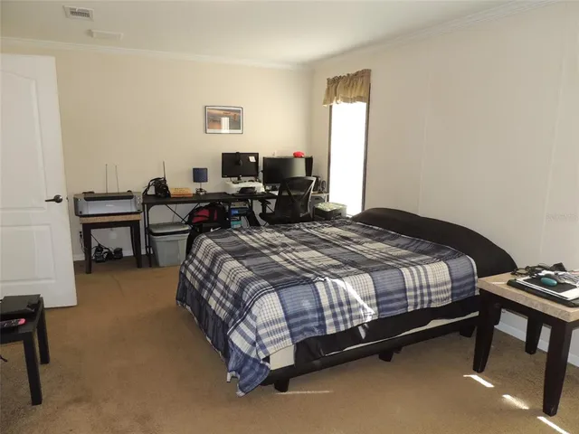 a spacious bedroom with a bed and a desk