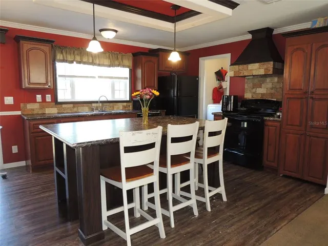 a kitchen with a dining table chairs stainless steel appliances and cabinets