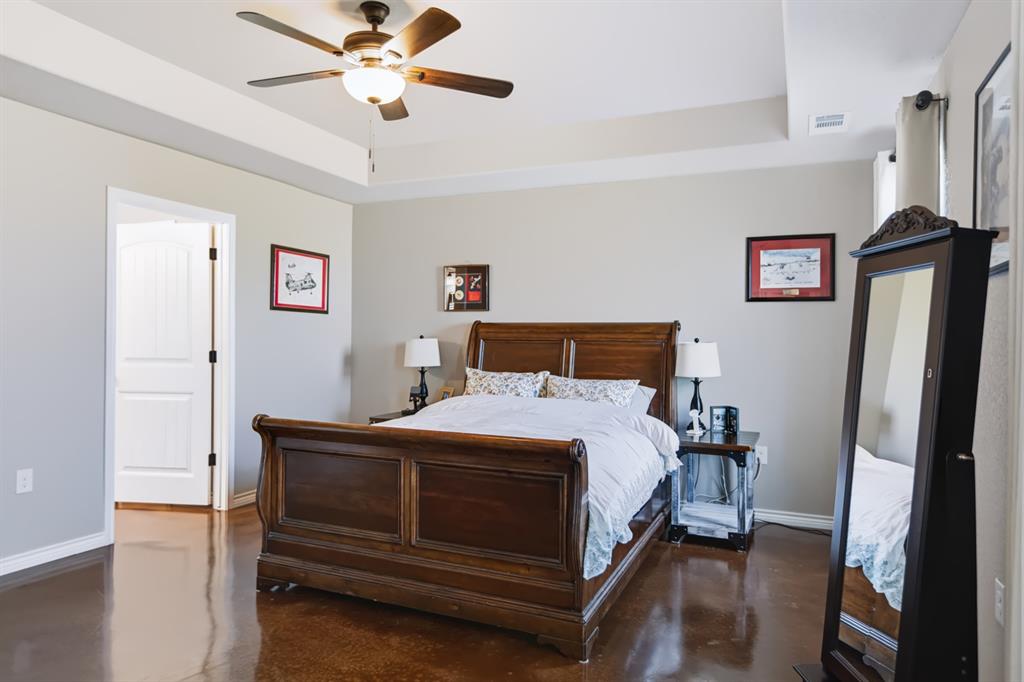 2433 Trlica Road West, TX 76691 - Photo 10 of 40 Tray ceiling with a ceiling fan, wood-finish flooring, and white paneled interior doors