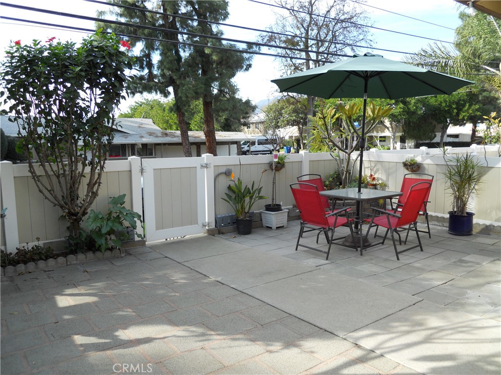 750 East 5th Street, Unit 51 Azusa, CA 91702 - Photo 25 of 59 a view of a table and chairs under an umbrella in backyard