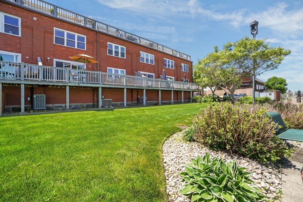 45 Main Street, Unit 112 Wareham, MA 02571 - Photo 20 of 30 a view of a house with a yard and potted plants