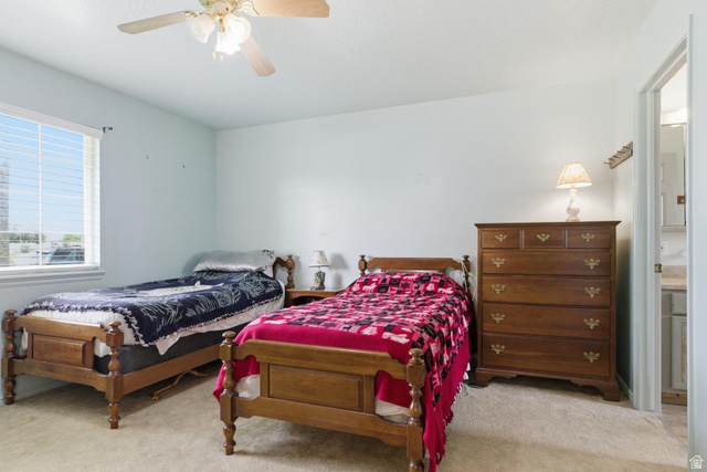 435 East 4th North Preston, ID 83263 - Photo 9 of 26 Carpeted bedroom featuring a ceiling fan with light fixture, a large window with horizontal blinds, and a neutral wall color