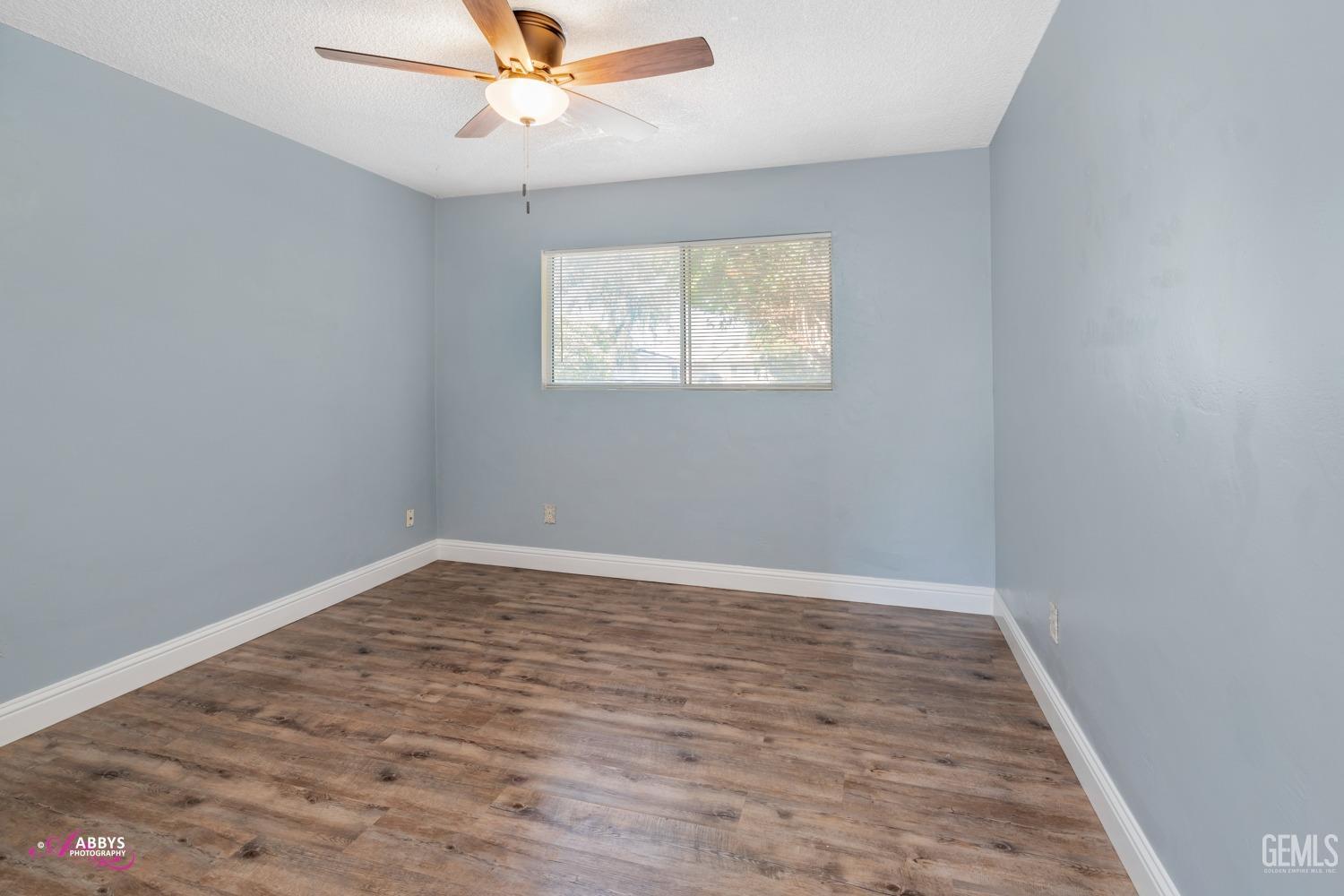 Undisclosed Address Bakersfield, CA 93309 - Photo 11 of 21 an empty room with wooden floor fan and windows