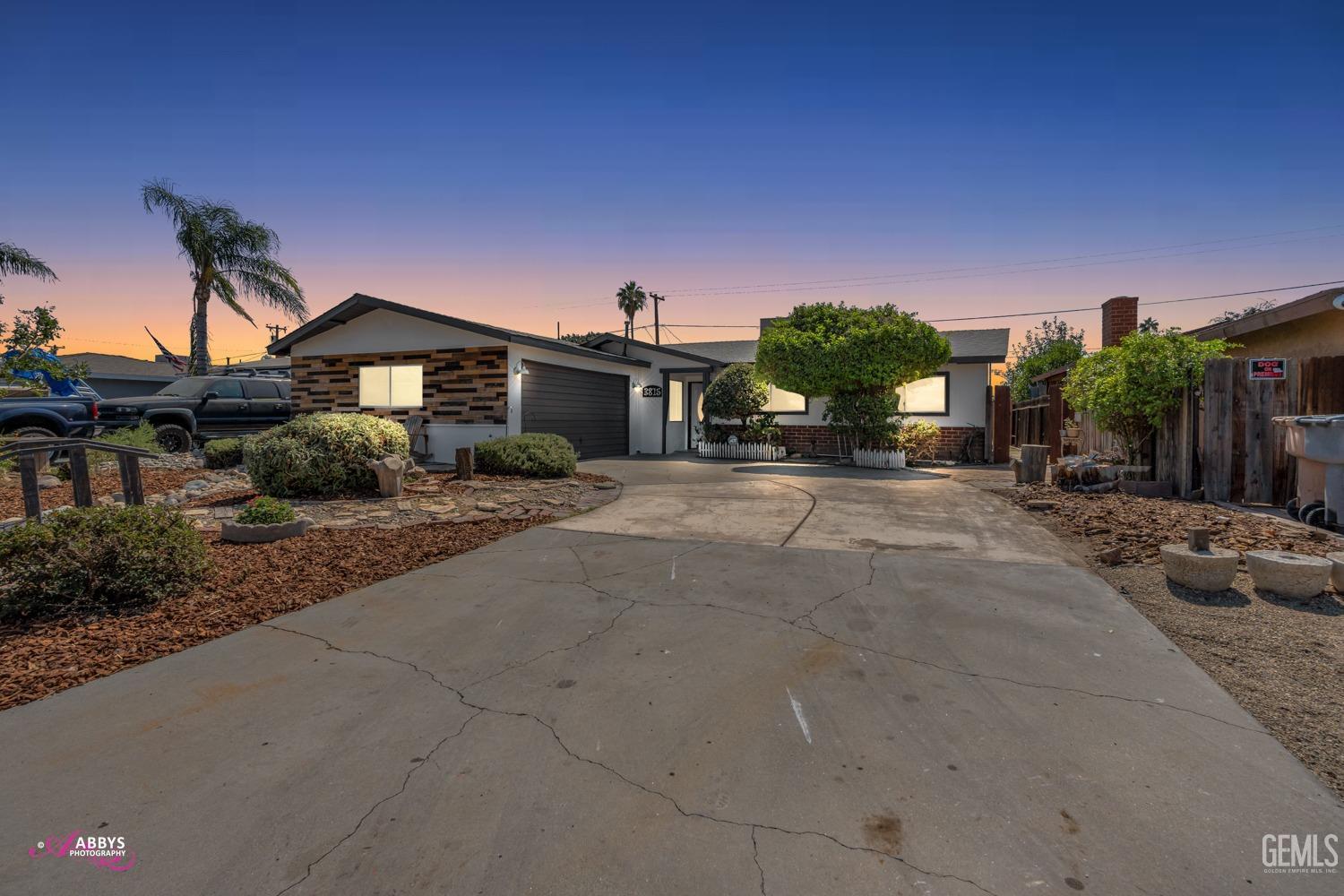 Undisclosed Address Bakersfield, CA 93309 - Photo 13 of 21 a front view of a house with a yard and garage