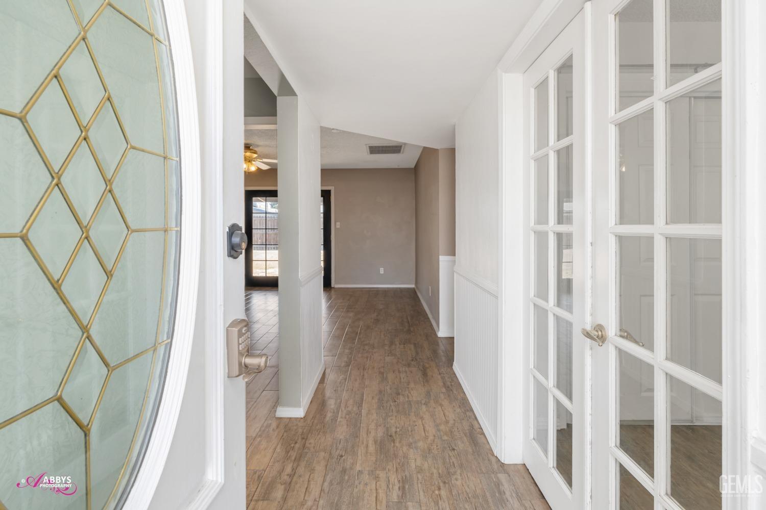 Undisclosed Address Bakersfield, CA 93309 - Photo 7 of 21 a view of a hallway with wooden floor and staircase
