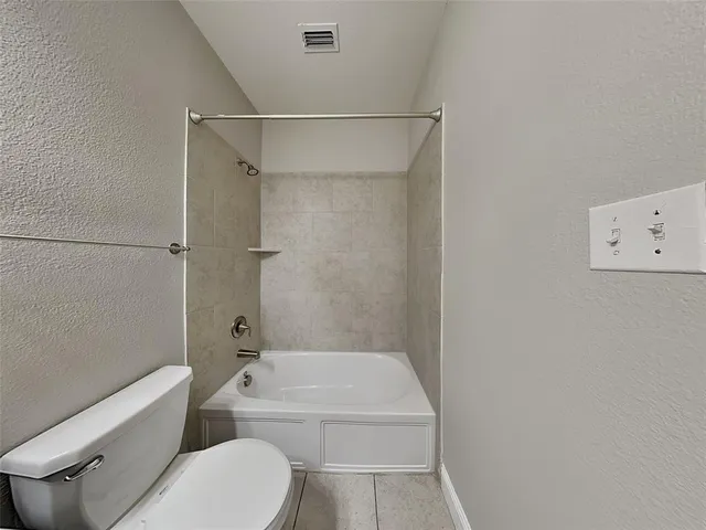 a bathroom with a toilet and a bath tub