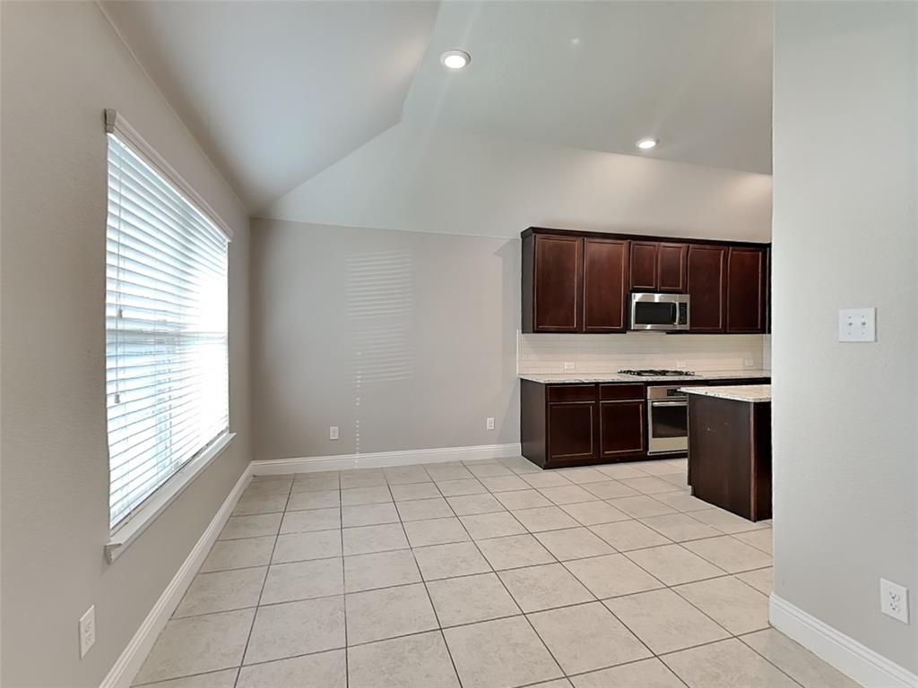 7248 Laguna Del Campo Trail Fort Worth, TX 76131 - Photo 5 of 15 a kitchen with stainless steel appliances a stove a sink and a microwave