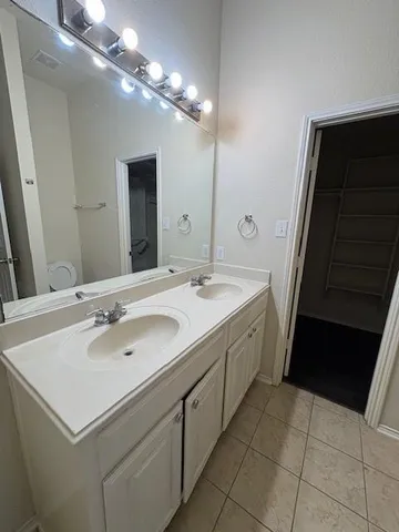 a bathroom with a double vanity sink toilet mirror and shower