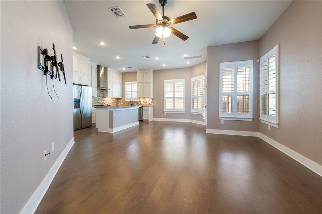 7811 Wildcat Pass Austin, TX 78757 - Photo 3 of 24 a view of a big room with wooden floor and a chandelier fan