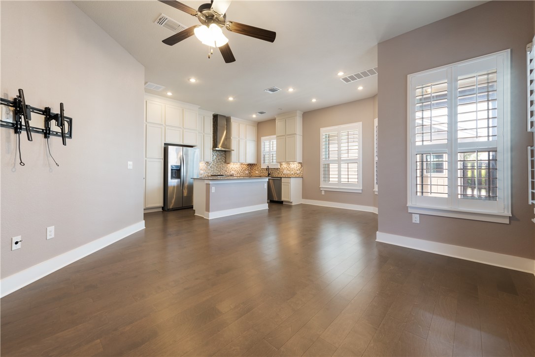 7811 Wildcat Pass Austin, TX 78757 - Photo 4 of 24 a view of a kitchen with a stove cabinets a ceiling fan and wooden floor