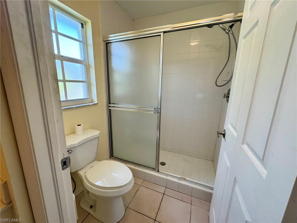 2153 Sunshine Boulevard, Unit 4 Naples, FL 34116 - Photo 12 of 19 Bathroom featuring toilet, an enclosed shower, and tile patterned floors
