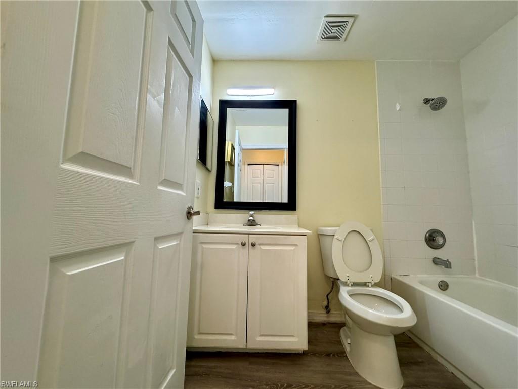 2153 Sunshine Boulevard, Unit 4 Naples, FL 34116 - Photo 13 of 19 Full bathroom with vanity, toilet, hardwood / wood-style floors, and tiled shower / bath