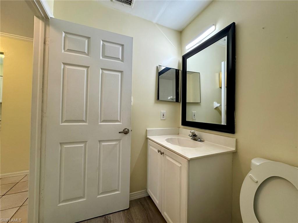 2153 Sunshine Boulevard, Unit 4 Naples, FL 34116 - Photo 14 of 19 Bathroom with vanity, toilet, and wood-type flooring