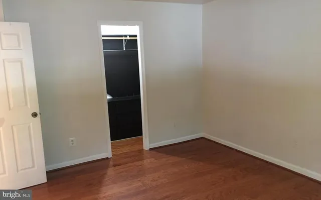 an empty room with wooden floor and closet