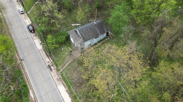 an aerial view of a house with a yard and large trees