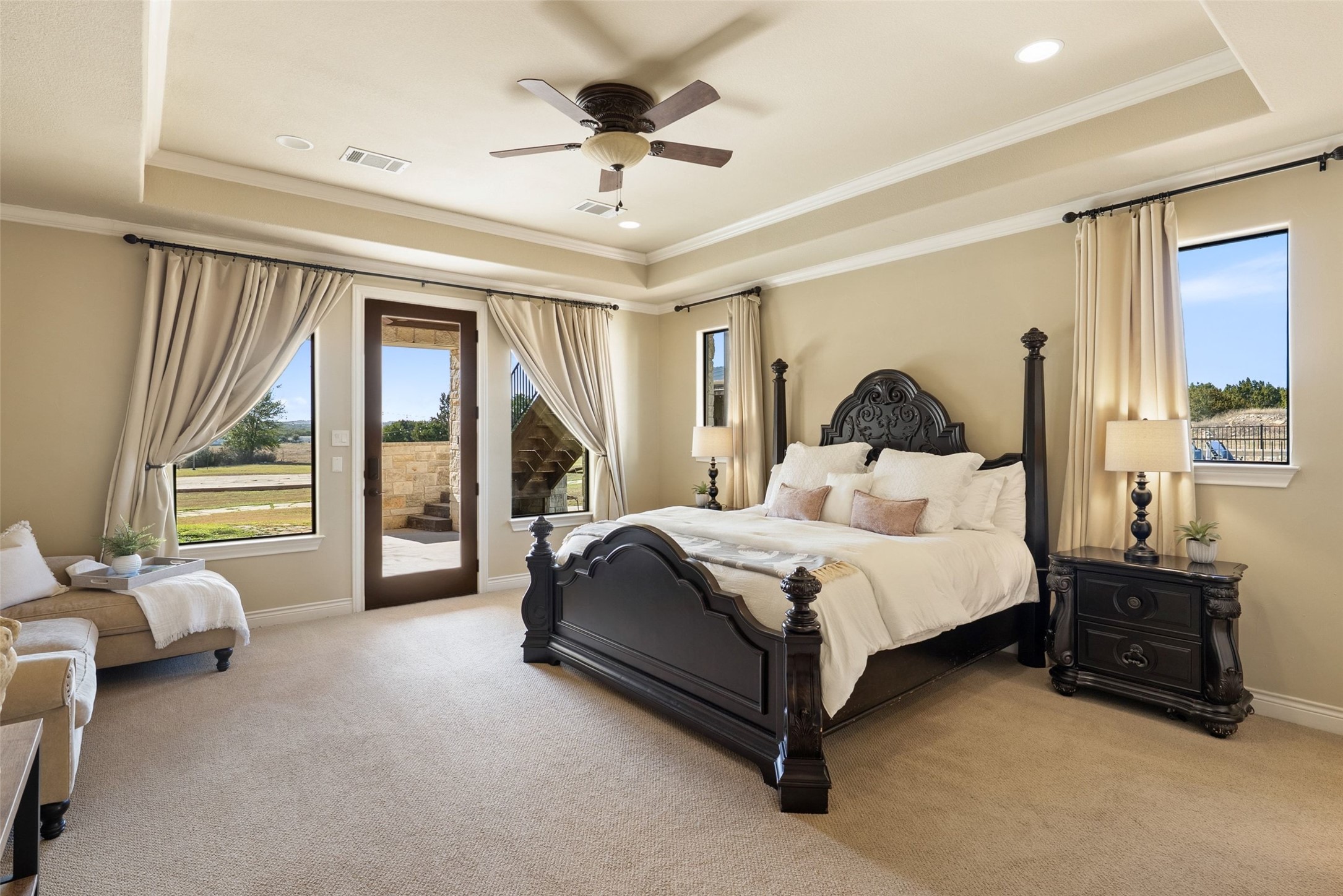 7220 Creek Road Dripping Springs, TX 78620 - Photo 14 of 40 a spacious bedroom with a bed and a chandelier