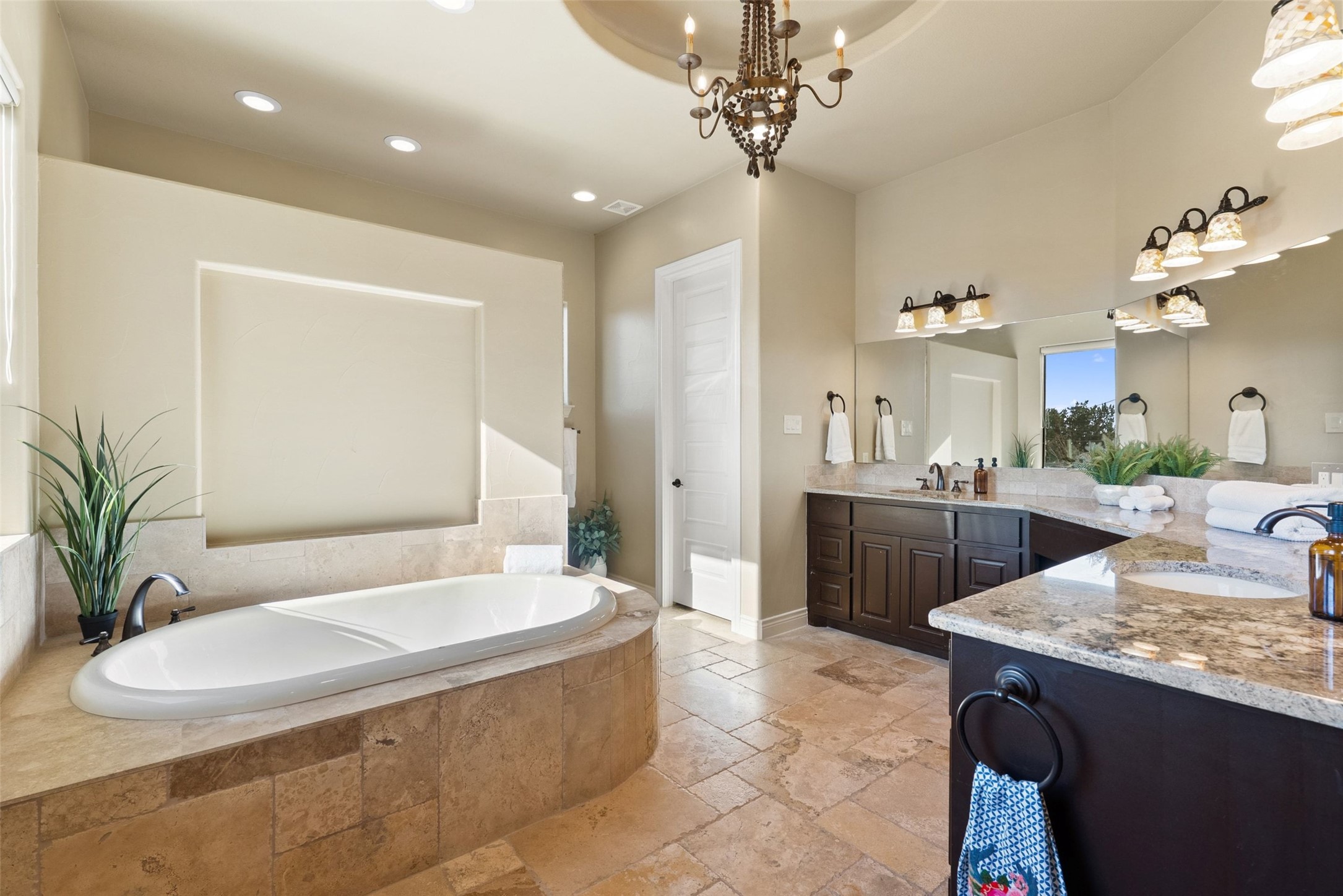 7220 Creek Road Dripping Springs, TX 78620 - Photo 15 of 40 a spacious bathroom with a granite countertop sink a toilet a mirror and shower