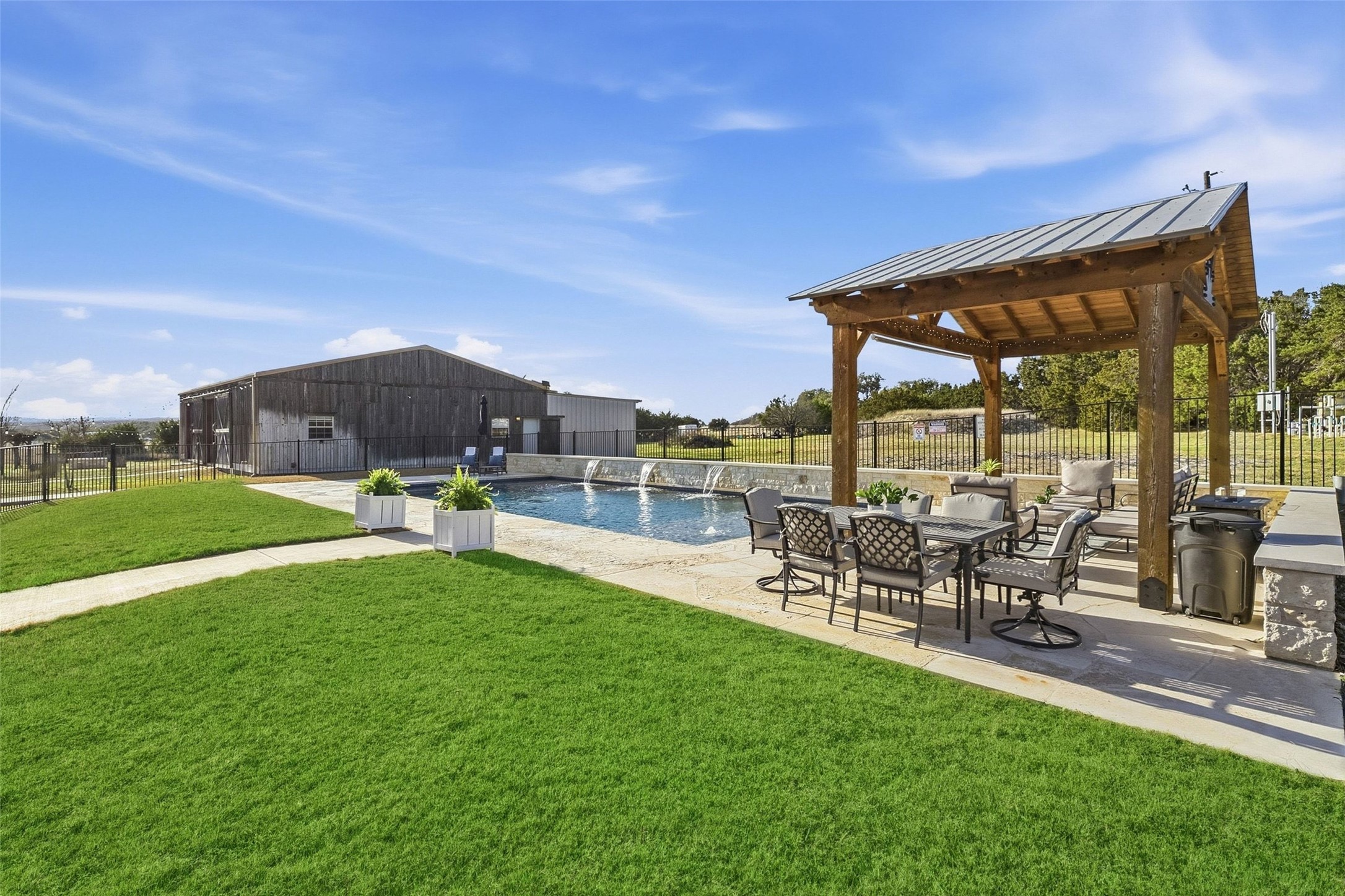 7220 Creek Road Dripping Springs, TX 78620 - Photo 28 of 40 a view of a patio with table and chairs under an umbrella