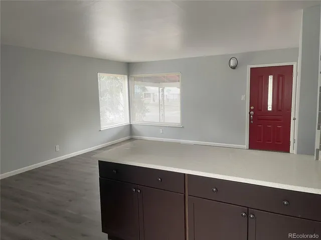 an empty room with wooden floor and cabinet