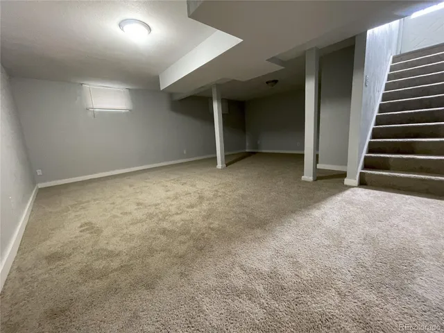 an empty room with a fireplace and stairs