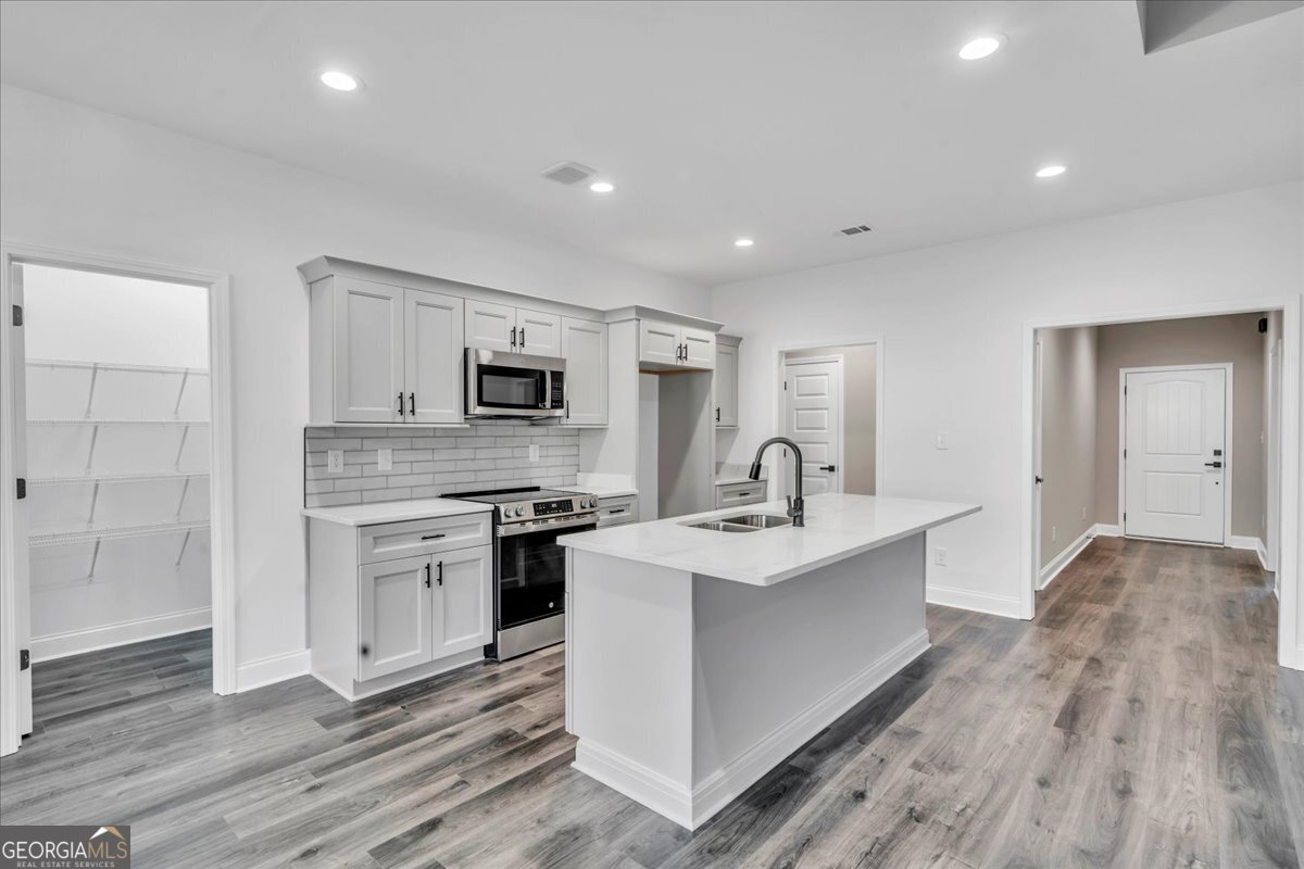 202 Eric Court Byron, GA 31008 - Photo 11 of 44 a view of a kitchen with sink stainless steel appliances and wooden floor