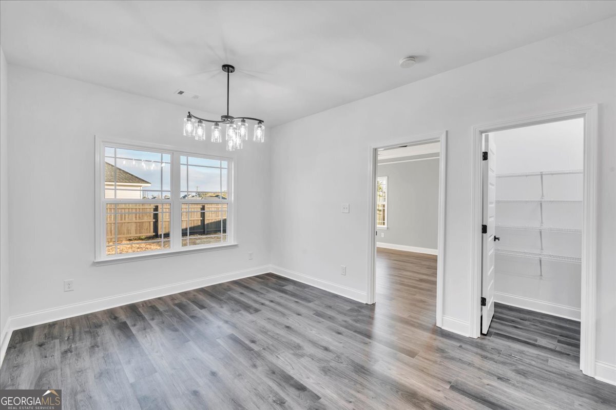 202 Eric Court Byron, GA 31008 - Photo 12 of 44 an empty room with wooden floor cabinet and windows