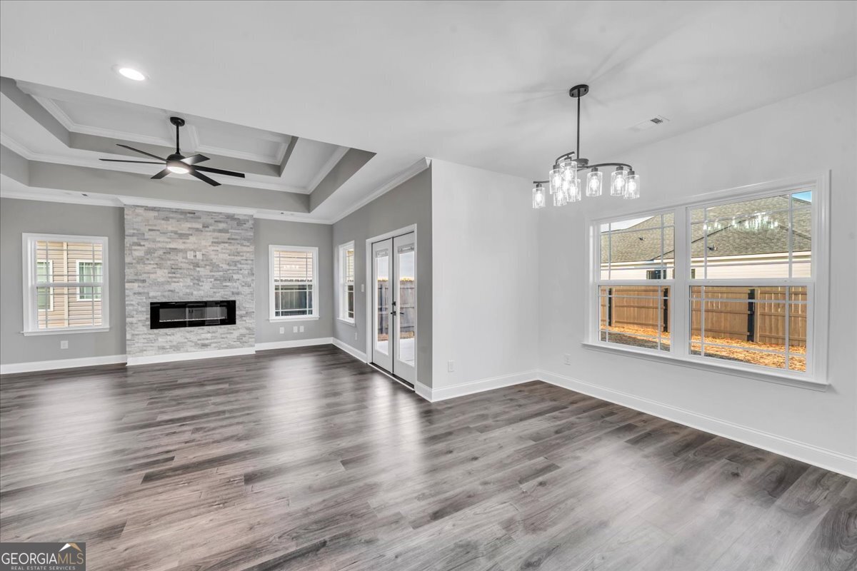 202 Eric Court Byron, GA 31008 - Photo 13 of 44 a view of an empty room with chandelier and wooden floor