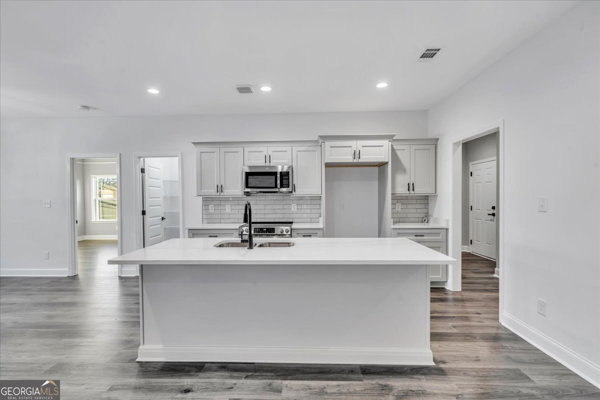 202 Eric Court Byron, GA 31008 - Photo 16 of 44 a large kitchen with stainless steel appliances a large counter top a stove and a refrigerator