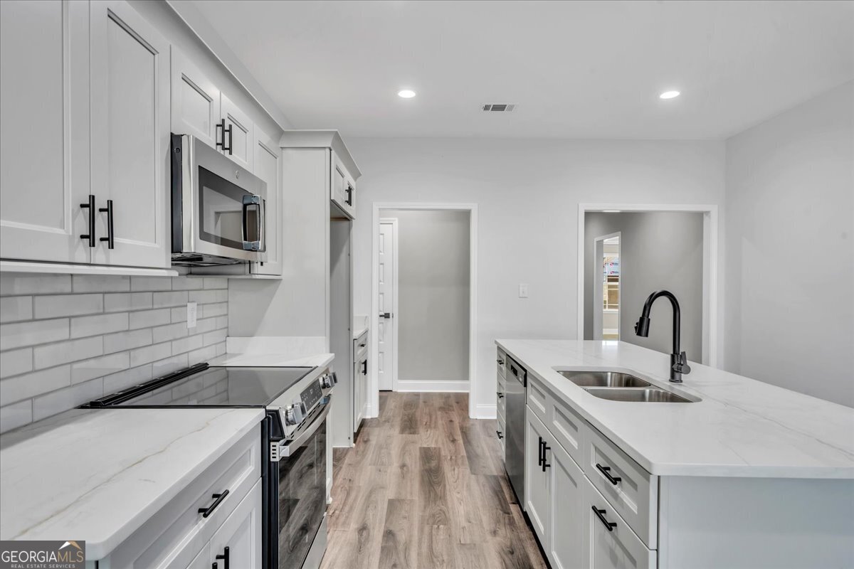 202 Eric Court Byron, GA 31008 - Photo 19 of 44 a kitchen with stainless steel appliances granite countertop a sink stove and refrigerator