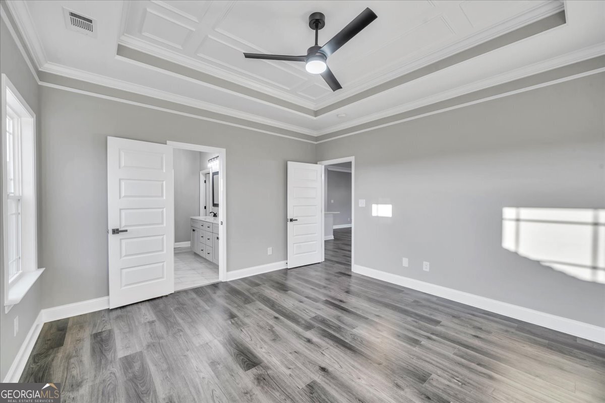 202 Eric Court Byron, GA 31008 - Photo 21 of 44 a view of a livingroom with wooden floor a ceiling fan and windows