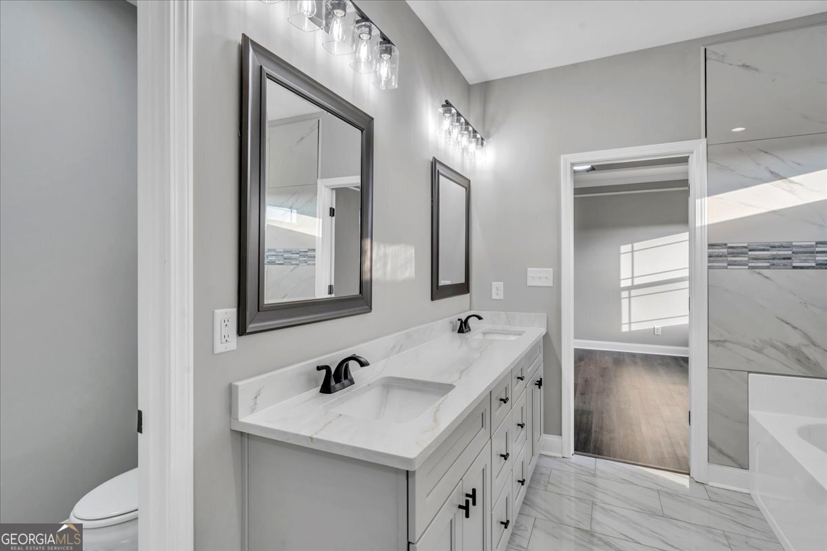202 Eric Court Byron, GA 31008 - Photo 30 of 44 a bathroom with a sink a toilet a mirror and shower
