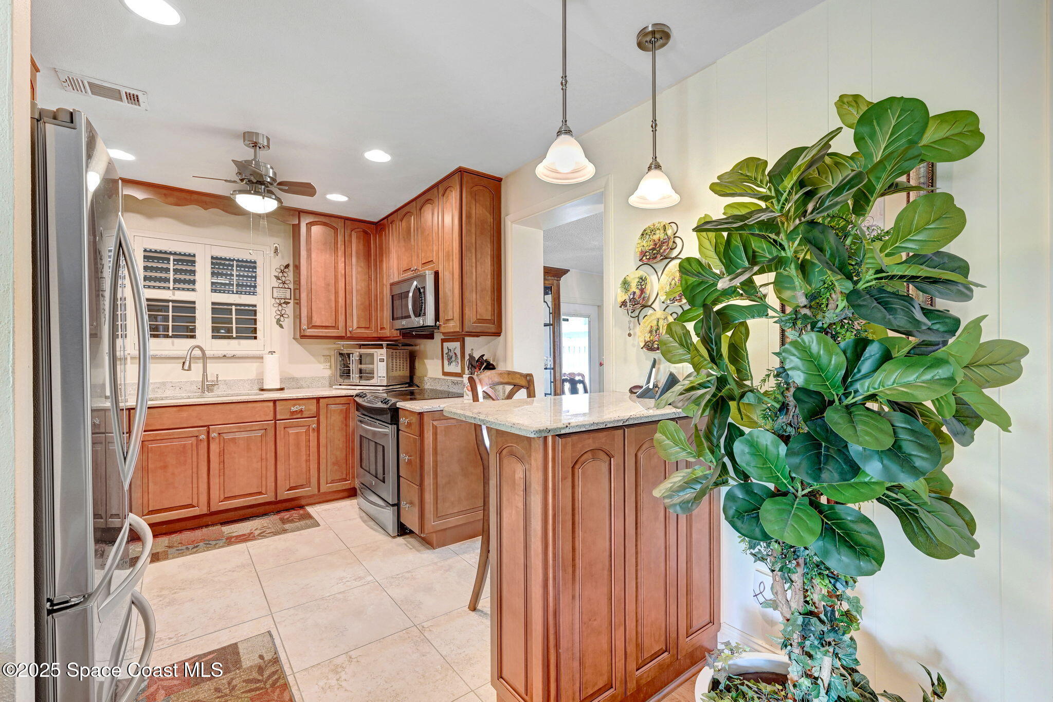 1208 Duke Way Cocoa, FL 32922 - Photo 9 of 34 a kitchen with stainless steel appliances a sink a oven a counter space and a view of living room