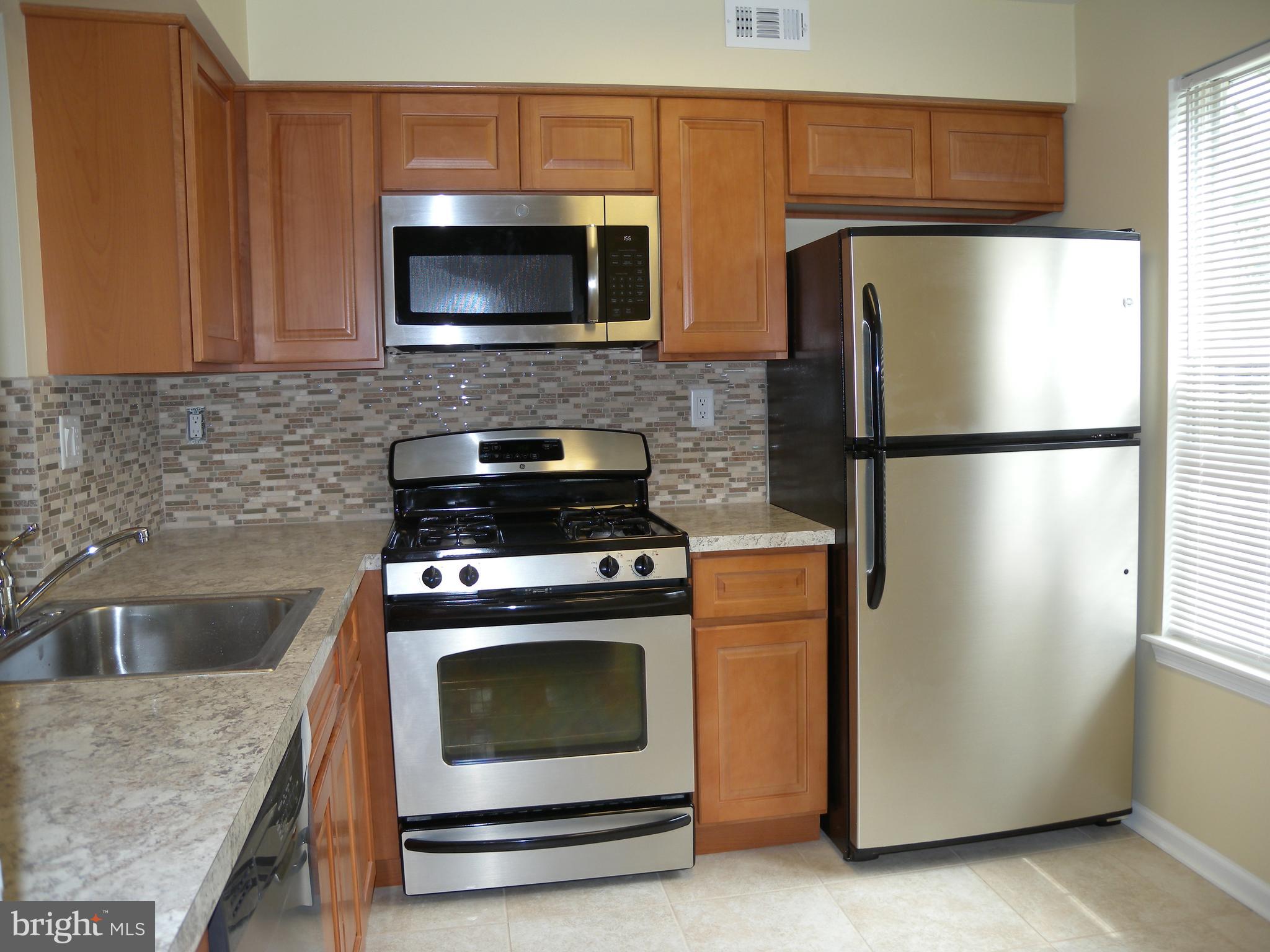 1907 A Sutton Place Mount Laurel, NJ 08054 - Photo 5 of 23 a kitchen with a stove microwave and refrigerator