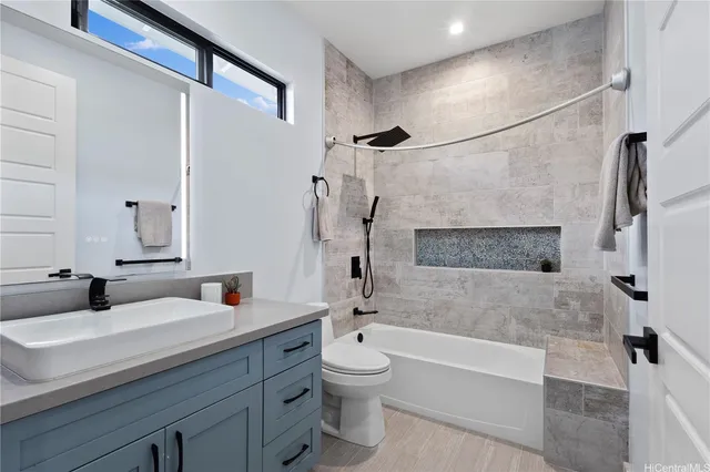 a bathroom with a granite countertop sink a toilet and shower