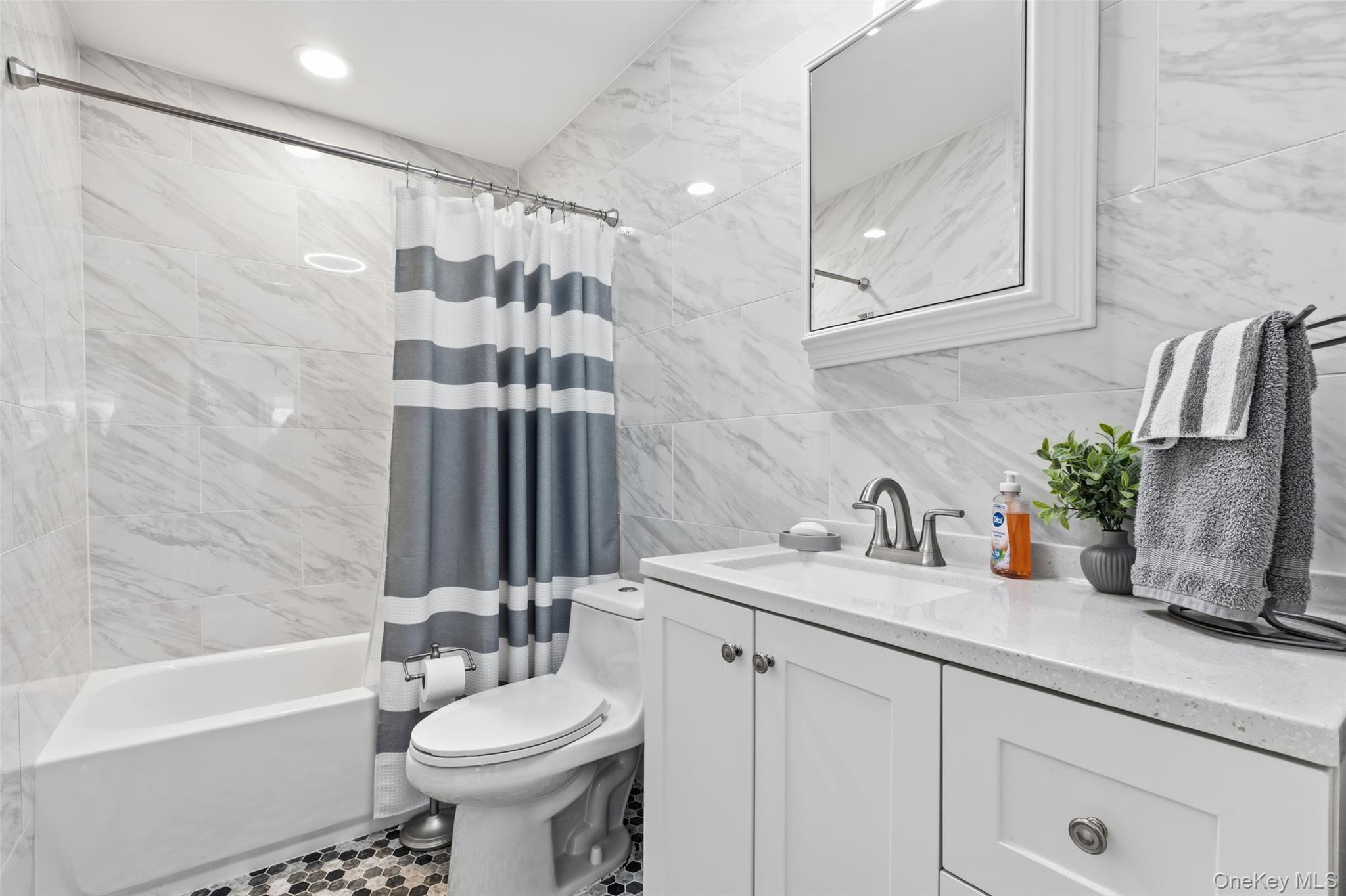39 Benjamin Road Mahopac, NY 10541 - Photo 14 of 39 Hallway bathroom with vanity, tiled walls and floors. Shower / tub combo