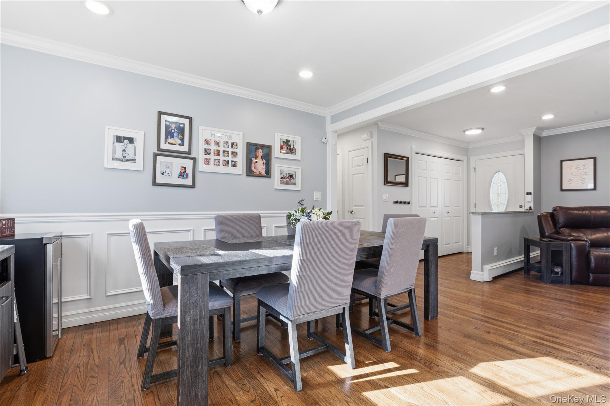 39 Benjamin Road Mahopac, NY 10541 - Photo 6 of 39 Dining area with crown molding, wood-style floors, baseboard heating, a wainscoted wall, and a decorative wall