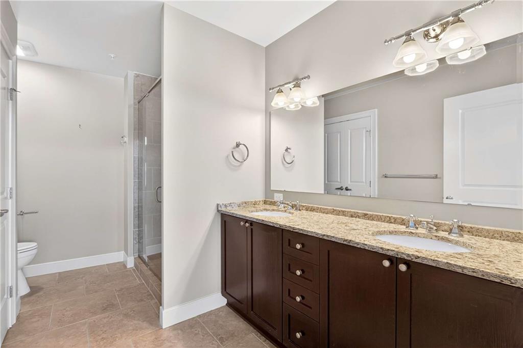 201 West Ponce De Leon Avenue, Unit 702 Decatur, GA 30030 - Photo 28 of 41 a bathroom with a granite countertop sink and a mirror