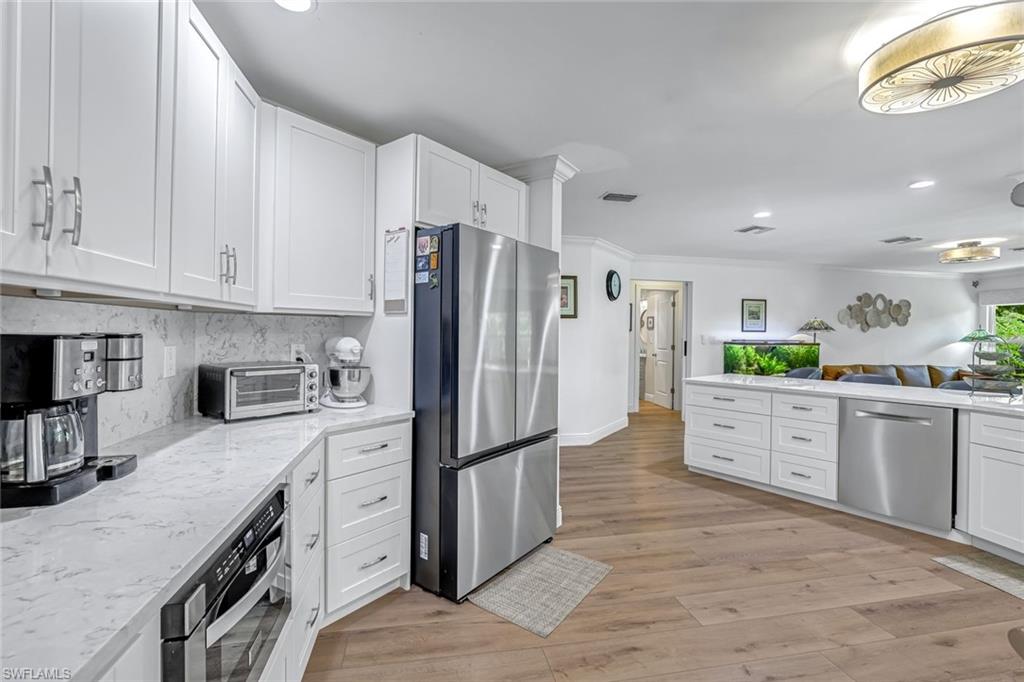 401 Panay Avenue Naples, FL 34113 - Photo 13 of 47 a kitchen with stainless steel appliances granite countertop a refrigerator a stove and a sink