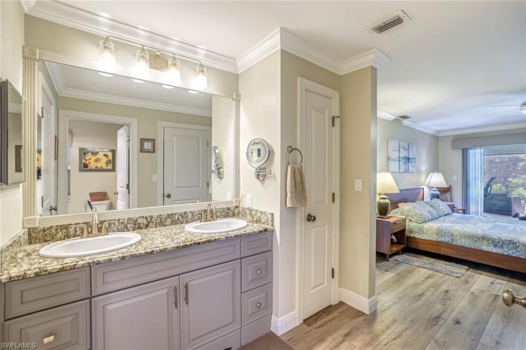 401 Panay Avenue Naples, FL 34113 - Photo 23 of 47 a en suite bathroom with a granite countertop sink and a mirror
