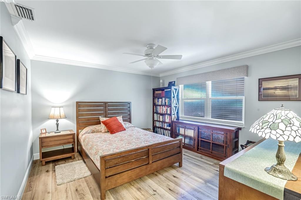 401 Panay Avenue Naples, FL 34113 - Photo 24 of 47 a bedroom with a bed lamps and wooden floor