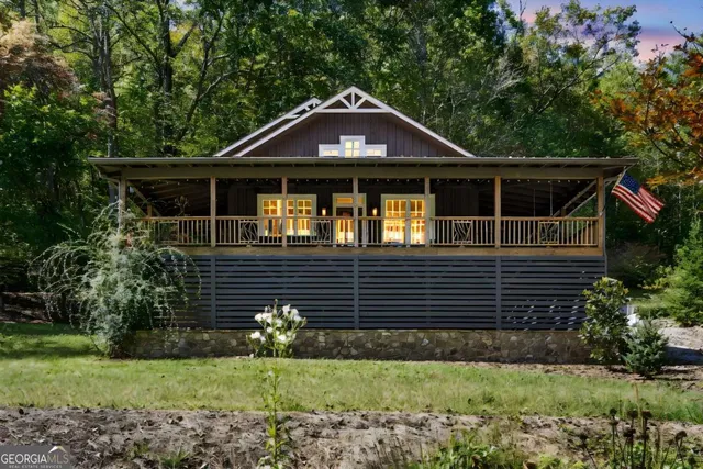 a view of a patio with table and chairs potted plants and large tree