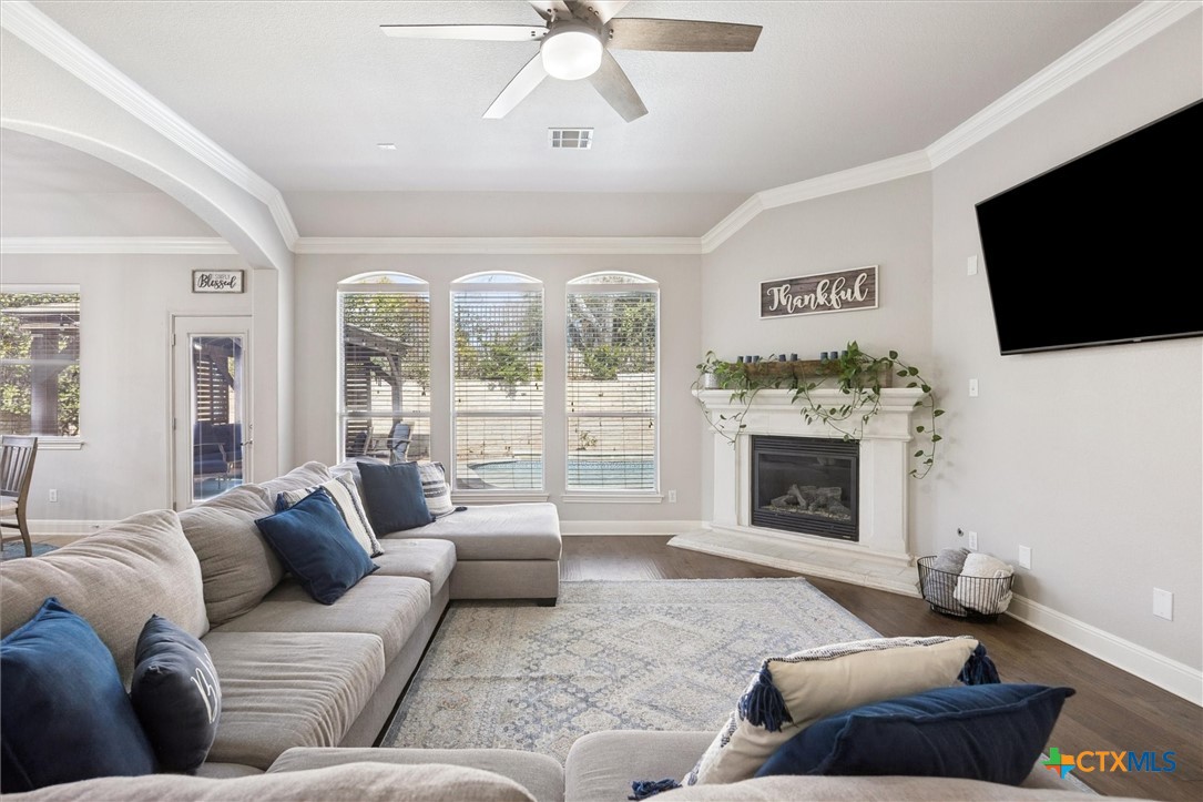 2309 First View Leander, TX 78641 - Photo 12 of 31 Large windows frame backyard views while a fireplace adds warmth and character to the heart of the home.