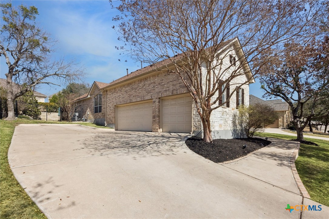 2309 First View Leander, TX 78641 - Photo 2 of 31 A long driveway provides generous parking space and leads to a spacious three-car garage, offering convenience and functionality.