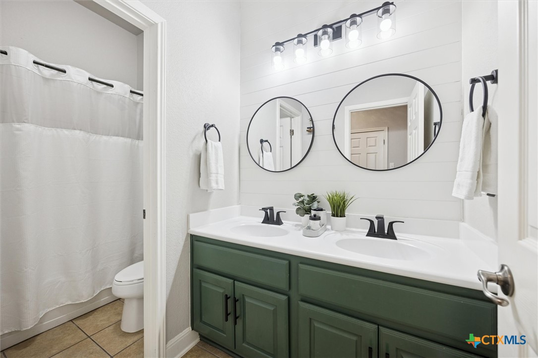 2309 First View Leander, TX 78641 - Photo 23 of 31 The secondary bathroom features a dual-sink vanity, updated lighting, and a clean, modern look with stylish finishes.