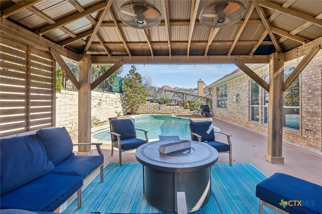 2309 First View Leander, TX 78641 - Photo 24 of 31 The covered patio overlooks the backyard retreat, offering a protected space to enjoy fresh air while taking in views of the pool and surrounding landscape.