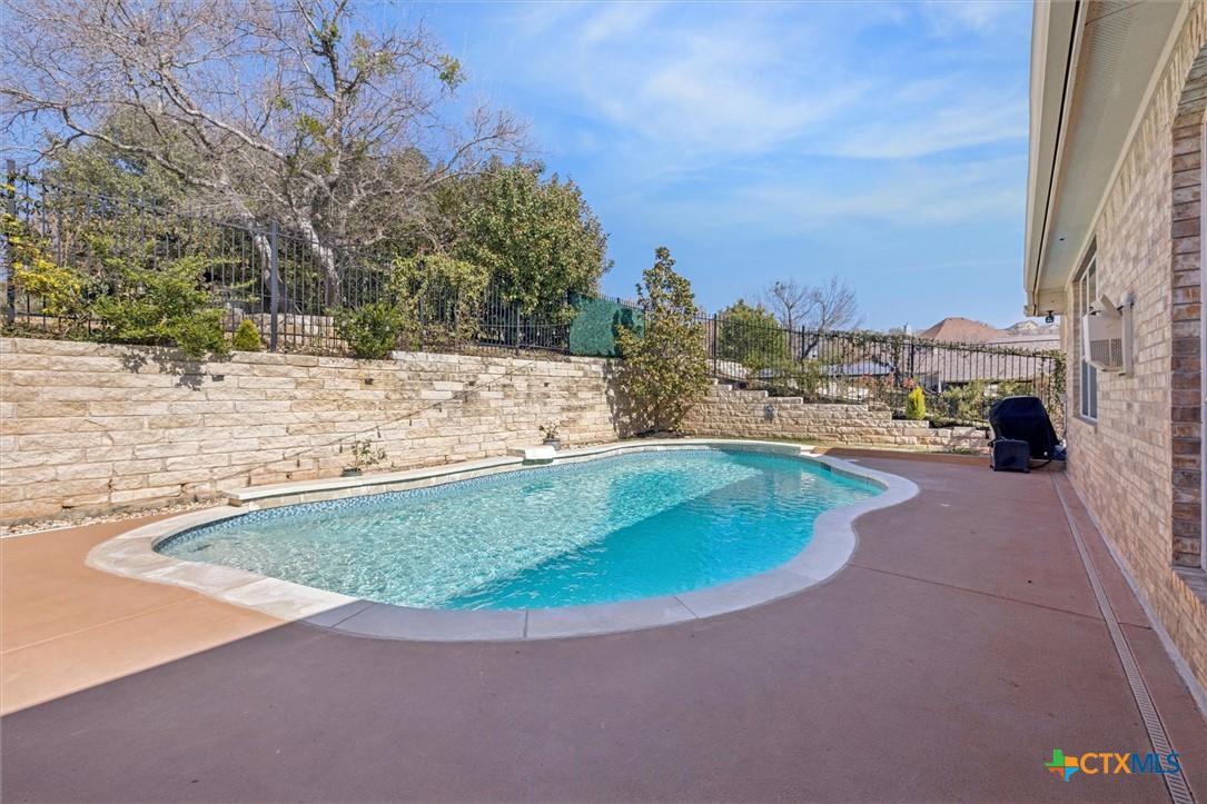 2309 First View Leander, TX 78641 - Photo 25 of 31 A sparkling in-ground pool is surrounded by an expansive patio, creating a private outdoor escape with room to relax under the open sky.