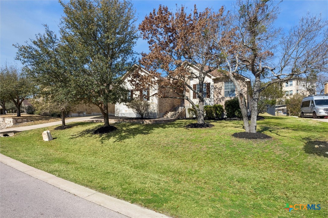 2309 First View Leander, TX 78641 - Photo 3 of 31 Mature trees and a broad lawn frame the elevated front of the home, creating a welcoming presence along the quiet neighborhood street.